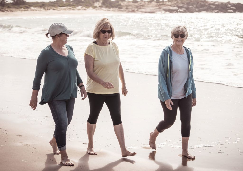 older women walking on beach