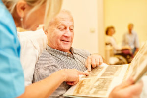 man with dementia looks at photo album