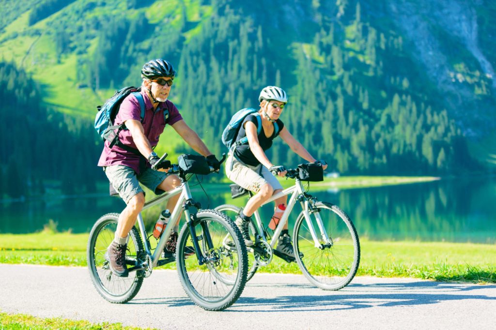 two people cycling by lake